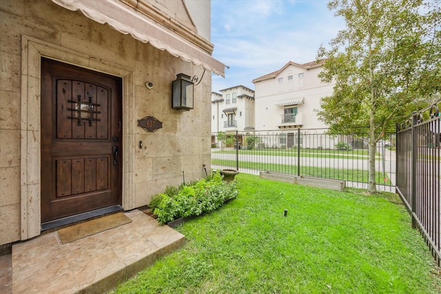 property entrance with a lawn