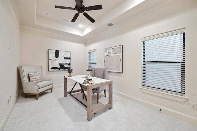 carpeted office with ceiling fan, a tray ceiling, and crown molding