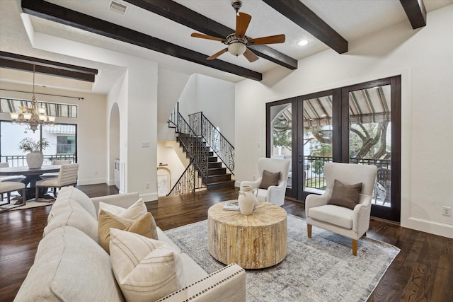 living room featuring beam ceiling, dark hardwood / wood-style flooring, french doors, and ceiling fan with notable chandelier