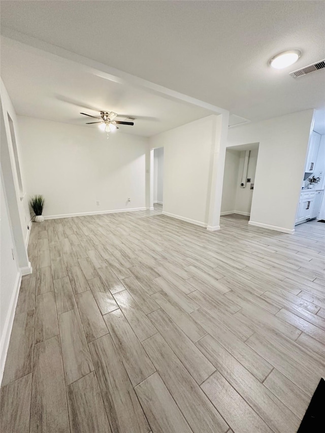 interior space featuring light wood-type flooring, ceiling fan, and a textured ceiling