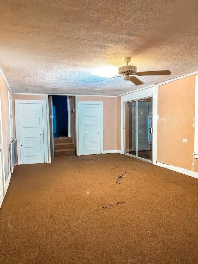 carpeted empty room with a textured ceiling and ceiling fan