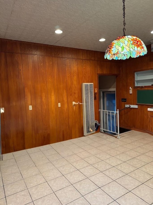 unfurnished room featuring light tile patterned flooring and wood walls