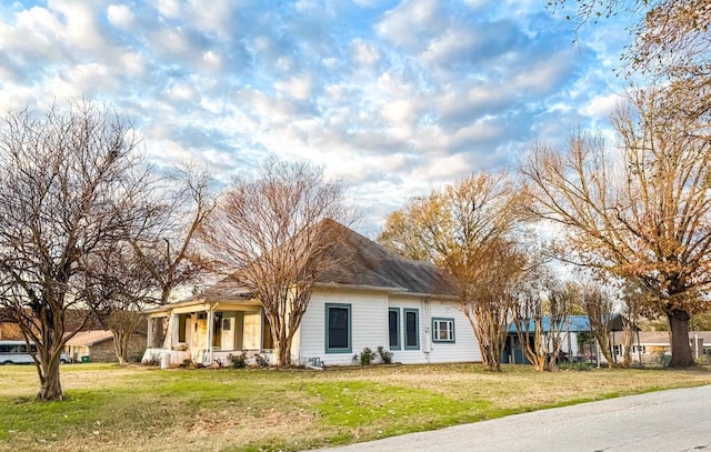 view of front of home featuring covered porch and a front lawn