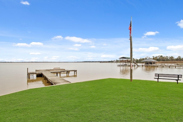 dock area with a water view and a lawn