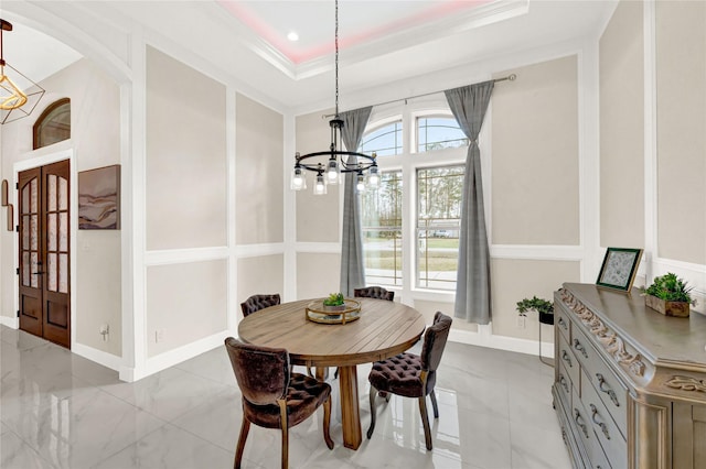 dining room featuring ornamental molding, an inviting chandelier, and a tray ceiling