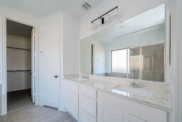 bathroom with a shower with door and vanity