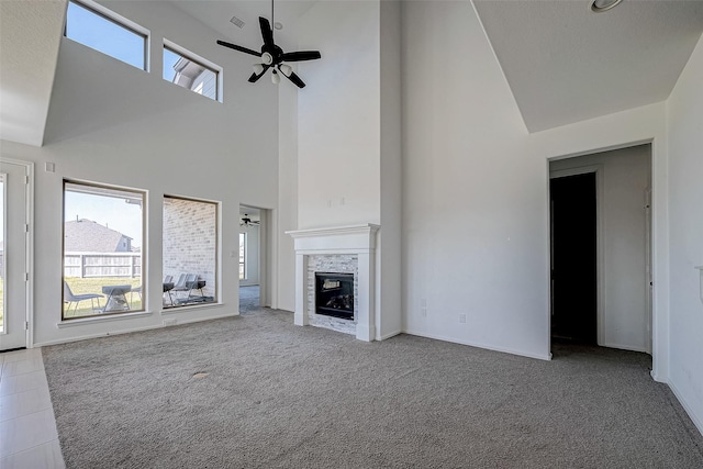 unfurnished living room featuring high vaulted ceiling, ceiling fan, a wealth of natural light, and light carpet