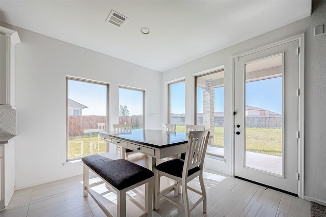 dining space featuring light tile patterned floors and a healthy amount of sunlight