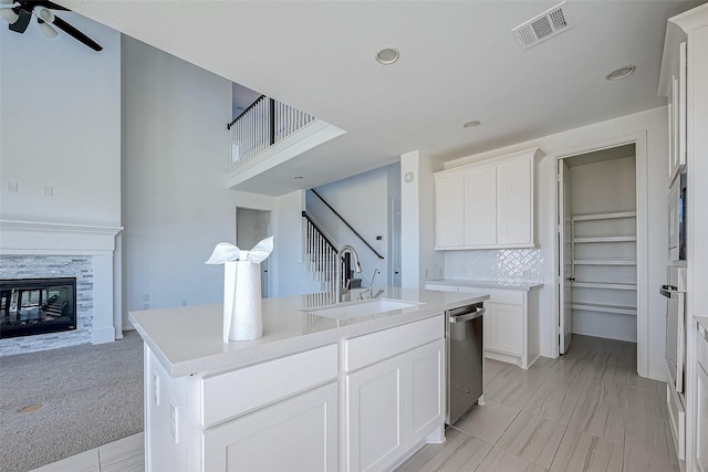 kitchen featuring sink, white cabinets, appliances with stainless steel finishes, and an island with sink