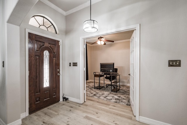 foyer entrance featuring ceiling fan with notable chandelier, crown molding, and light hardwood / wood-style flooring