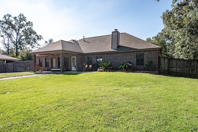 rear view of house featuring a yard