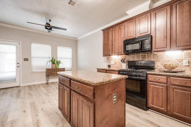 kitchen with a center island, ornamental molding, light hardwood / wood-style flooring, decorative backsplash, and black appliances