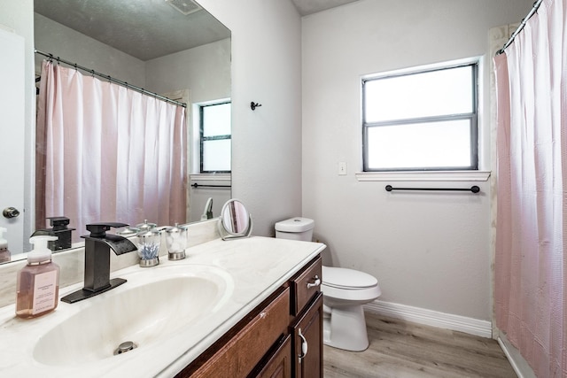 bathroom featuring toilet, hardwood / wood-style flooring, and vanity