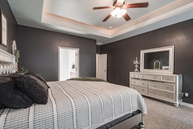 bedroom featuring ceiling fan, connected bathroom, a raised ceiling, and carpet floors