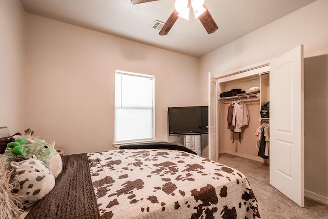 bedroom with a closet, ceiling fan, and light carpet