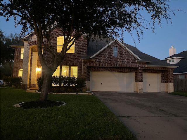 view of front of home with a yard and a garage