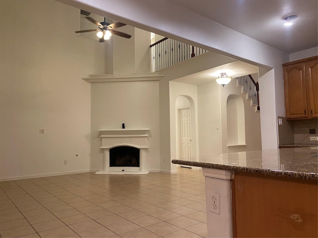 unfurnished living room featuring ceiling fan and light tile patterned floors