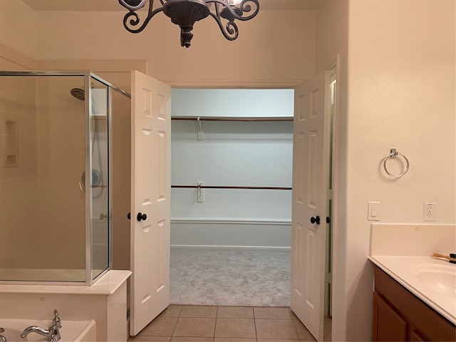 bathroom featuring a chandelier, tile patterned floors, walk in shower, and vanity