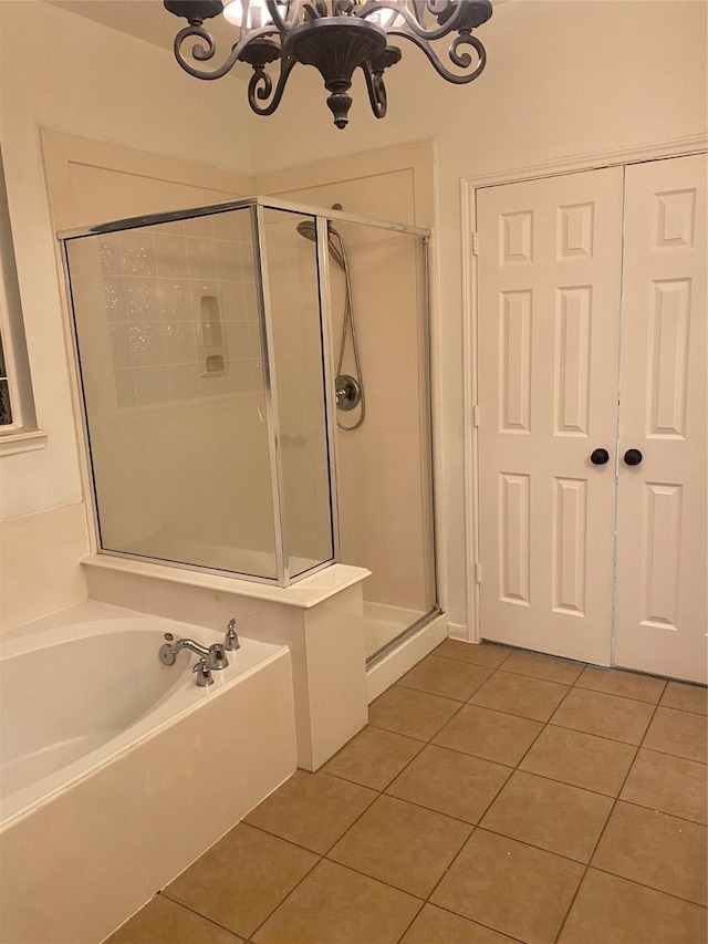 bathroom featuring independent shower and bath, a chandelier, and tile patterned floors