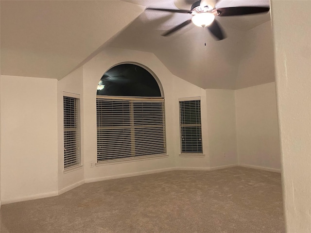 empty room with lofted ceiling, ceiling fan, and carpet