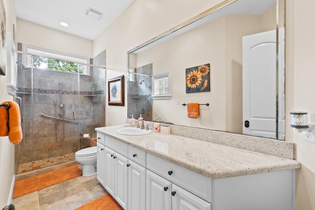 bathroom with toilet, a shower with shower door, and vanity