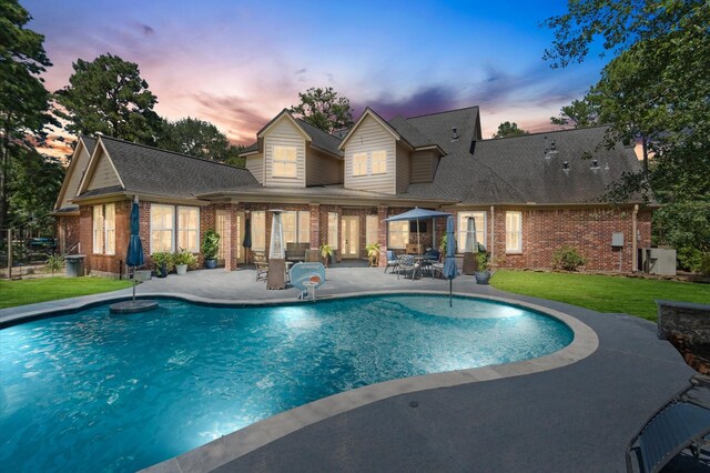 pool at dusk with a patio