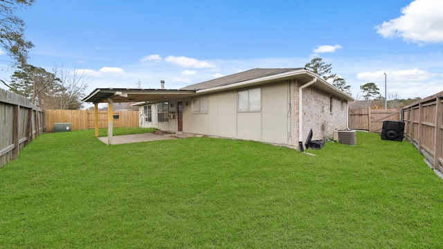 rear view of property with cooling unit, a patio, and a yard