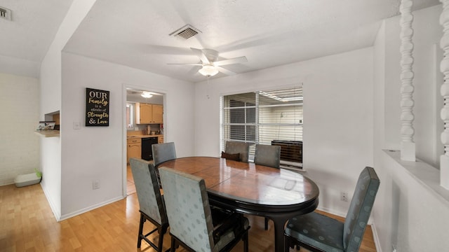 dining room featuring a textured ceiling, ceiling fan, and light hardwood / wood-style flooring