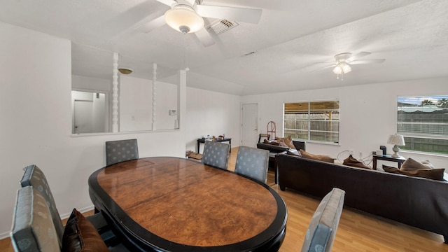 dining space with ceiling fan and light wood-type flooring