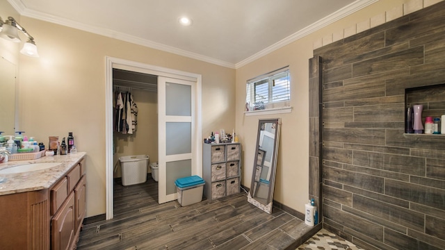 bathroom with toilet, crown molding, walk in shower, and vanity