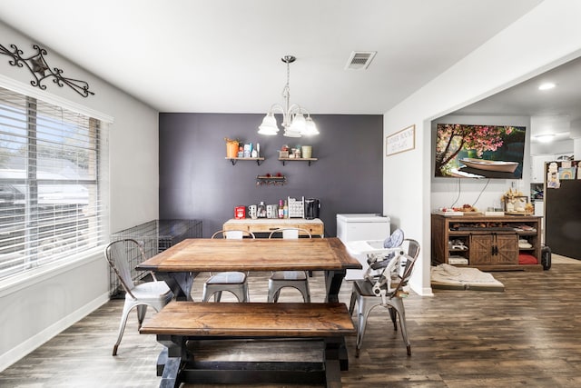 dining space featuring hardwood / wood-style flooring and a chandelier