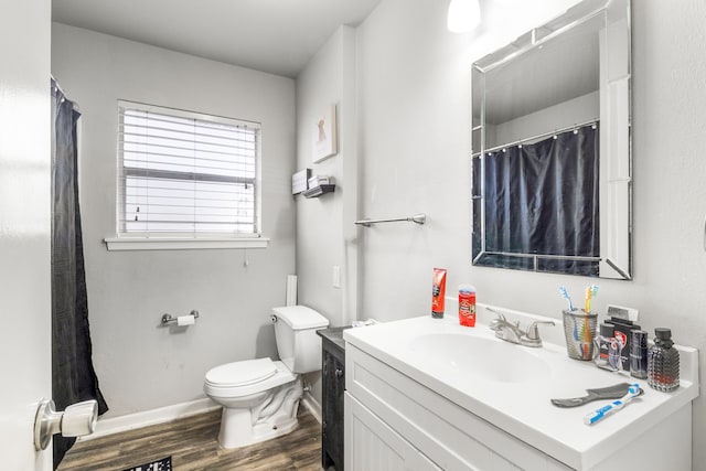 bathroom with wood-type flooring, curtained shower, vanity, and toilet