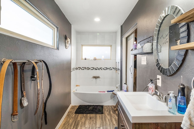 bathroom with tiled shower / bath, vanity, and hardwood / wood-style flooring