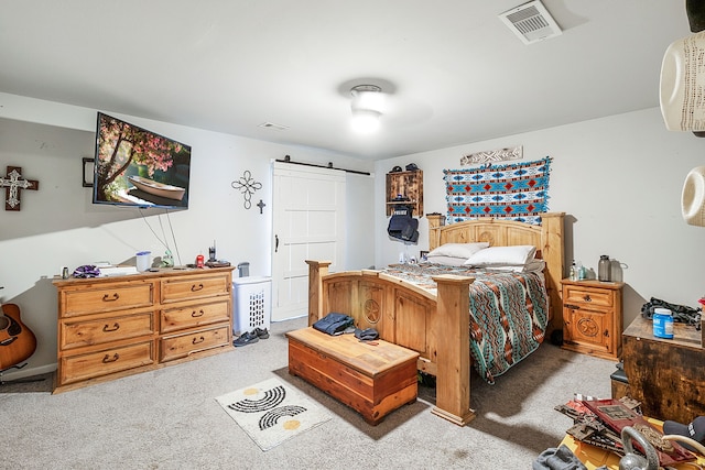 carpeted bedroom featuring a barn door