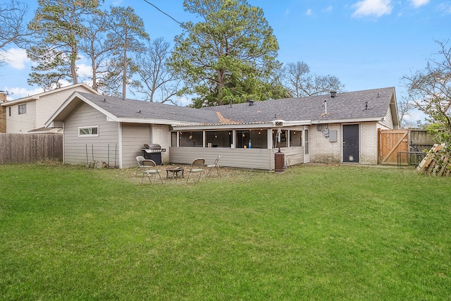 rear view of property with a fire pit and a yard