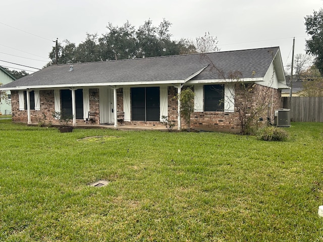 ranch-style house featuring a front yard, a porch, and central air condition unit