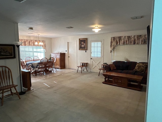 carpeted living room with a chandelier