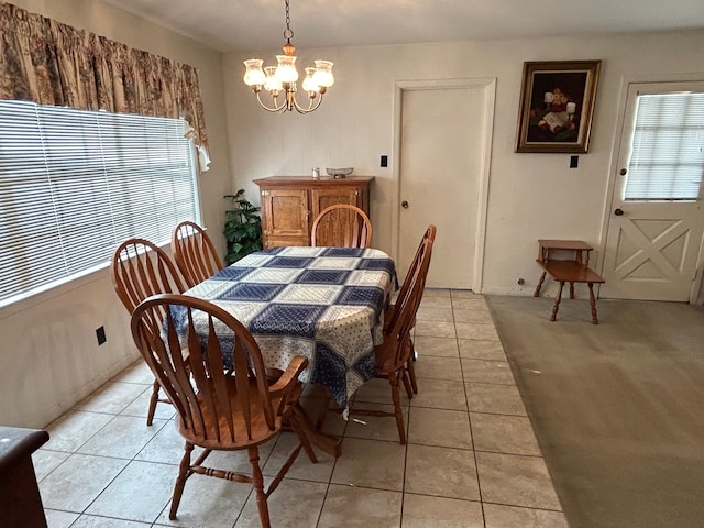 dining area with an inviting chandelier, light tile patterned floors, and plenty of natural light