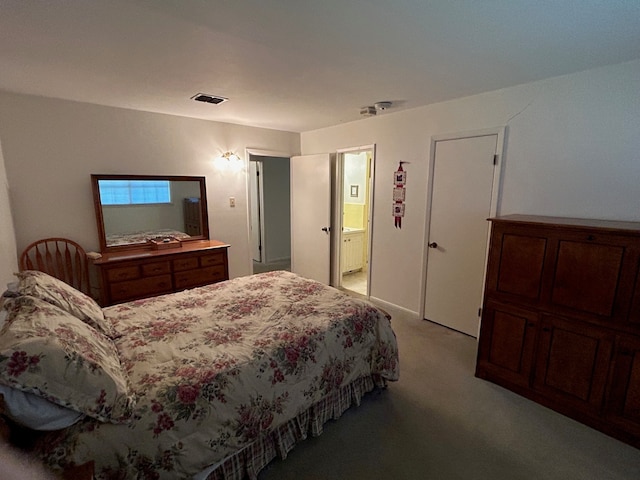 bedroom with ensuite bath and light carpet