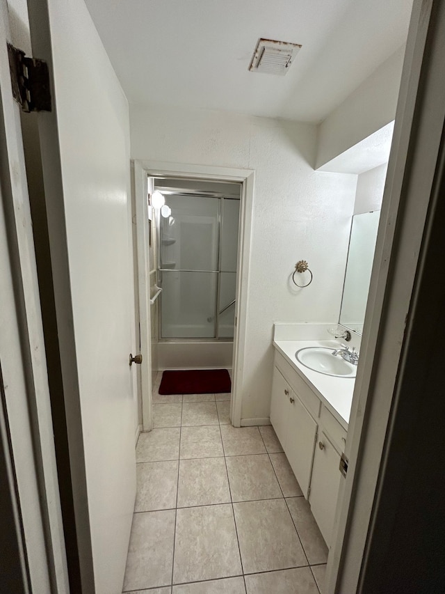 bathroom featuring bath / shower combo with glass door, tile patterned flooring, and vanity