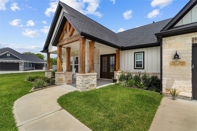 entrance to property featuring french doors, a porch, and a lawn