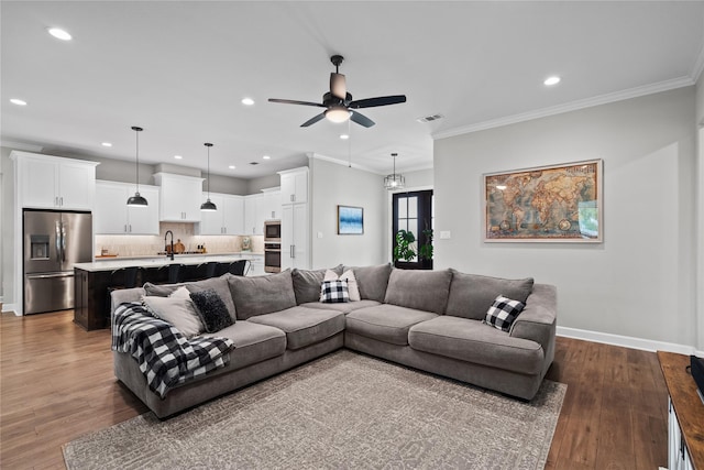 living room featuring hardwood / wood-style flooring, ceiling fan, and ornamental molding