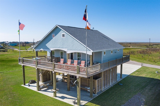 rear view of property featuring a patio, a deck, and a yard