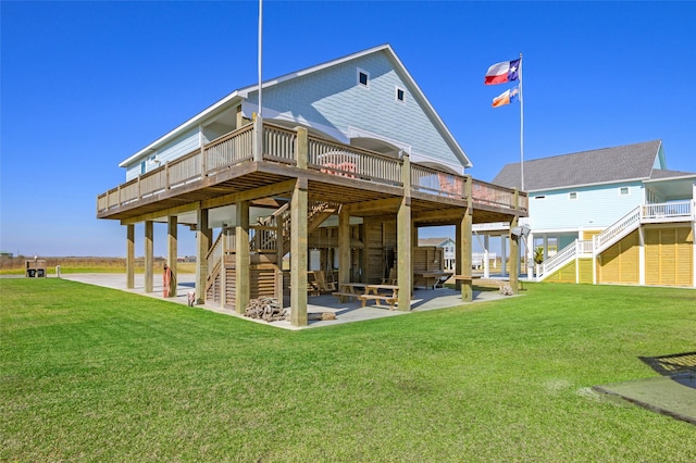 back of property with a lawn, a wooden deck, and a patio