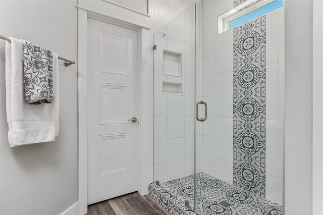 bathroom featuring hardwood / wood-style floors and a shower with shower door