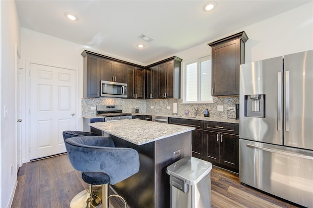 kitchen featuring a kitchen island, dark wood-type flooring, appliances with stainless steel finishes, and dark brown cabinetry