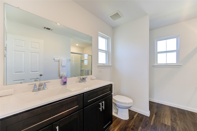 bathroom with wood-type flooring, an enclosed shower, vanity, and toilet