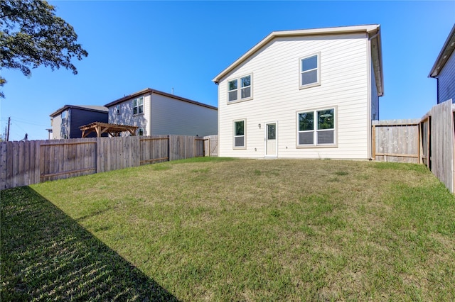 rear view of property featuring a yard