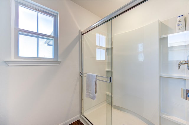 bathroom with a shower with shower door and wood-type flooring