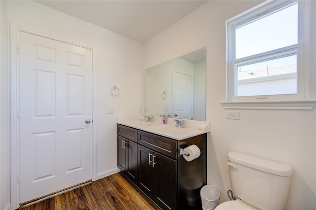 bathroom featuring toilet, vanity, and hardwood / wood-style floors